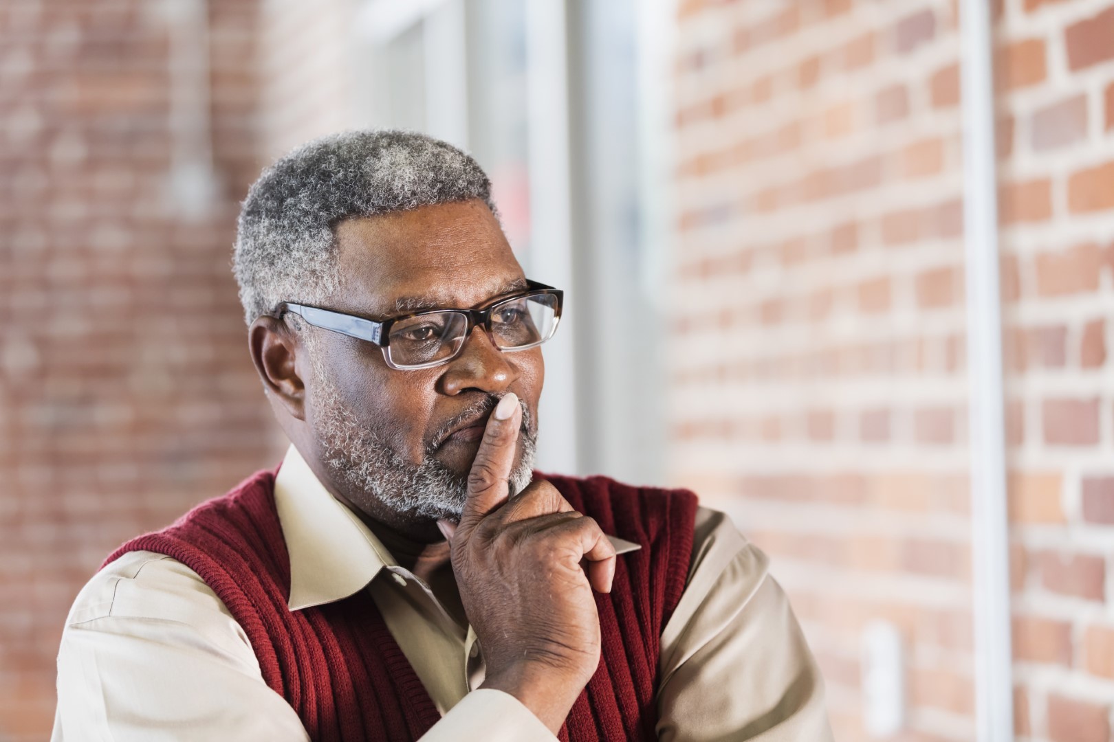 Senior African-American man, hand on chin, thinking